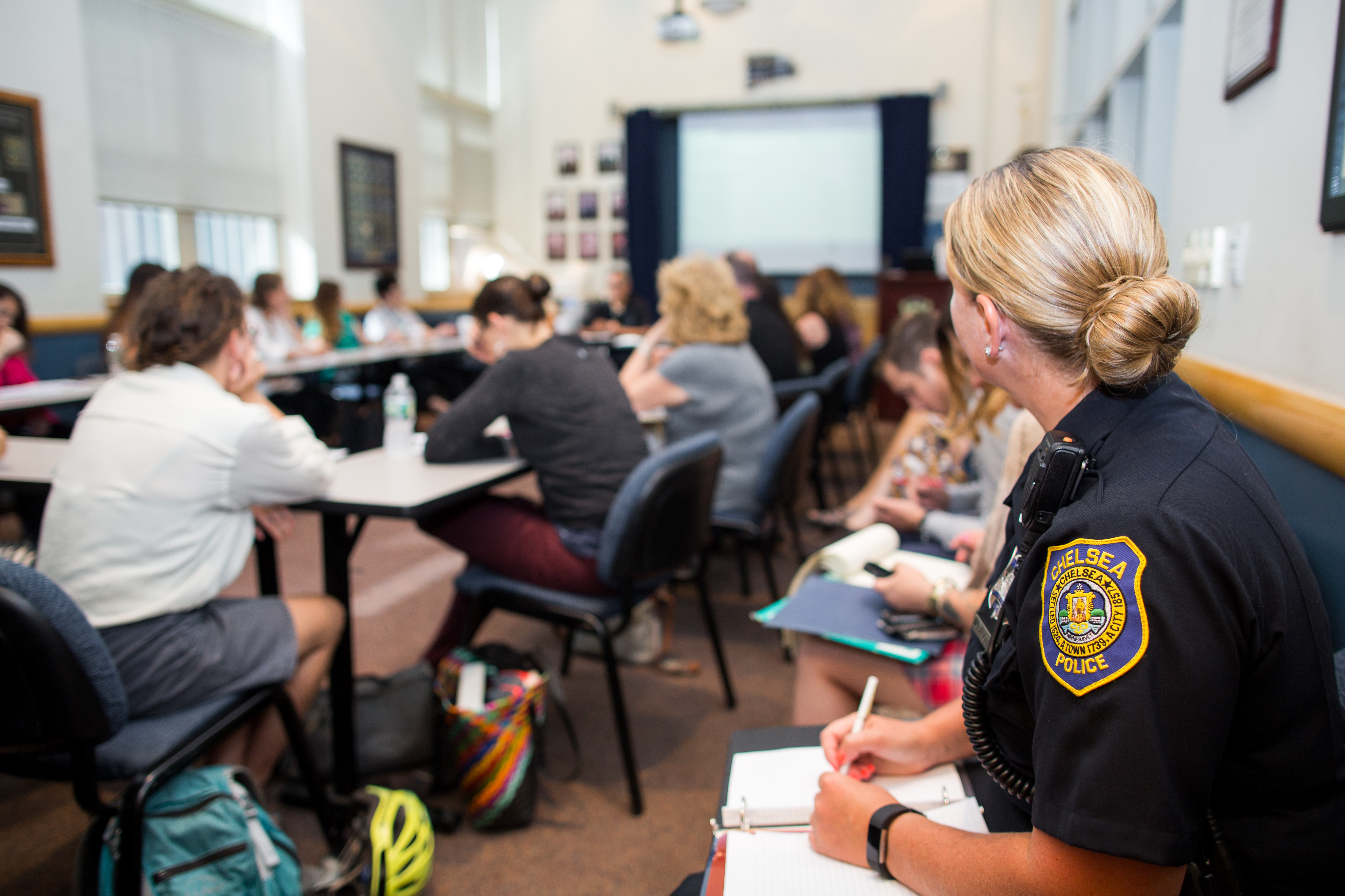 A police officer sits in a classroom