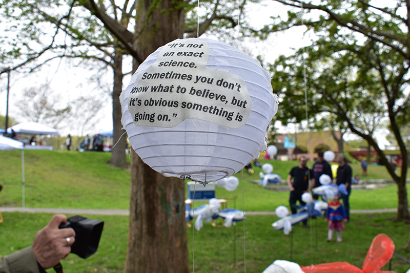 Hanging lanterns with quotes from construction workers at Wake Up the Earth 2019. Visible quote says "It's not an exact science. Sometimes you don't know what to believe, but it's obvious something is going on."