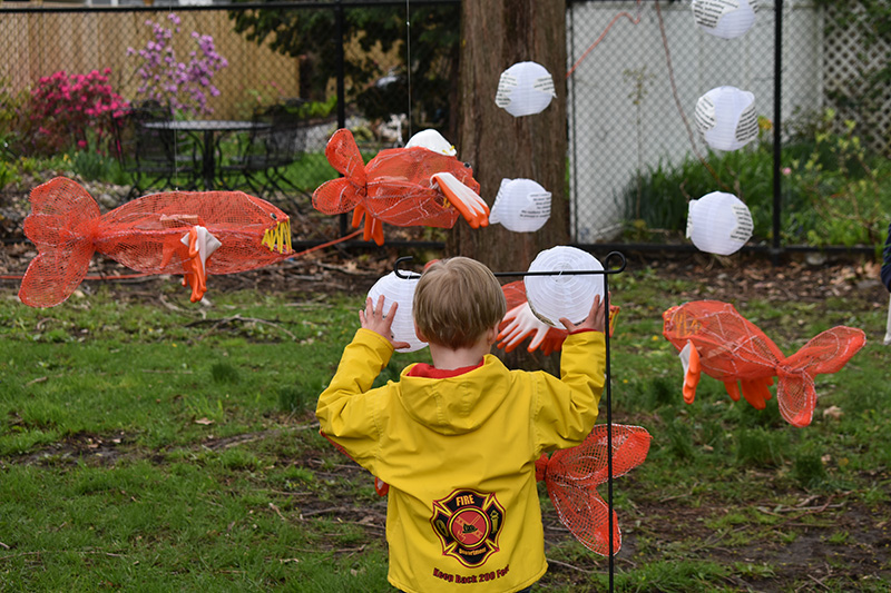 DSC_0062 Child playing with koi fish sculptures at Wake Up the Earth 2019