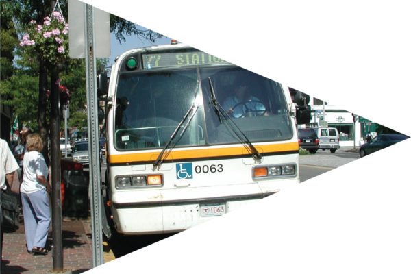 Image is a photo of a public transportation bus, and a person standing waiting to get on.
