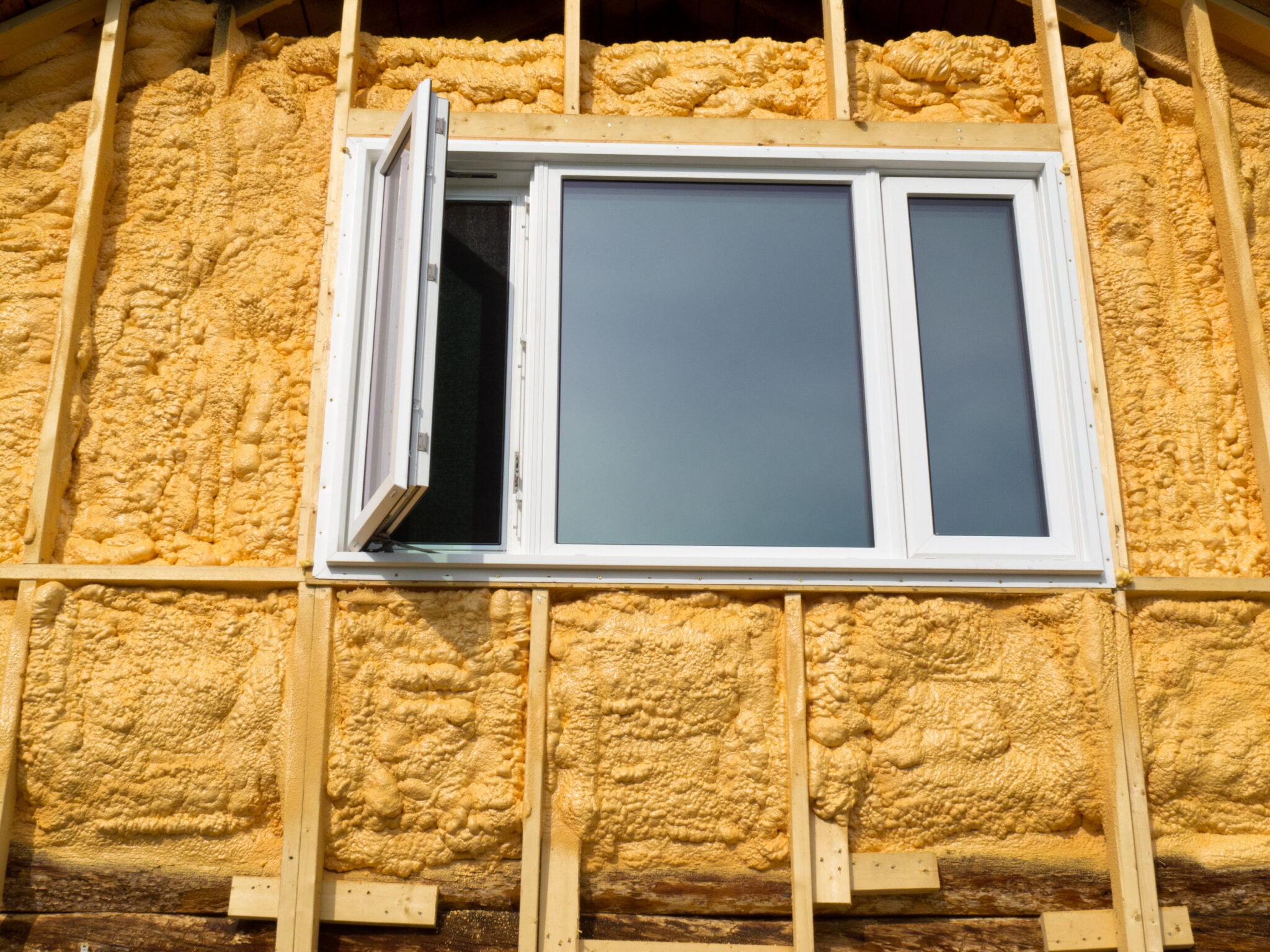 Side of a home with spray foam, and a window.
