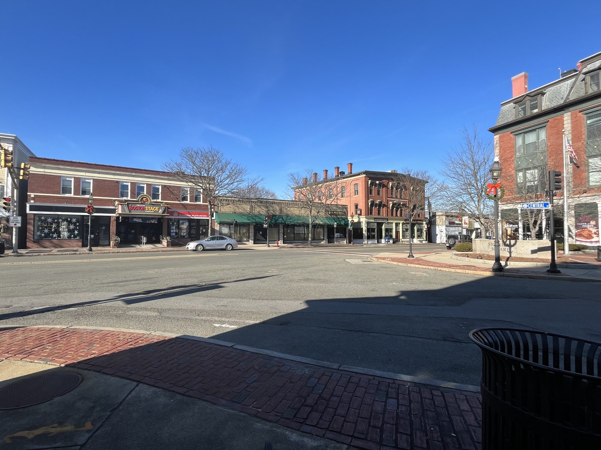 Panorama photo of Stoneham Square showing the traffic intersection and a variety of old, historic buildings.
