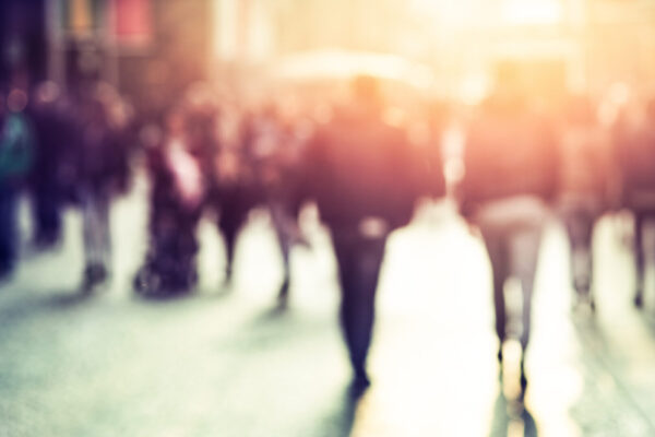 People walking in the street in a blurry photo.