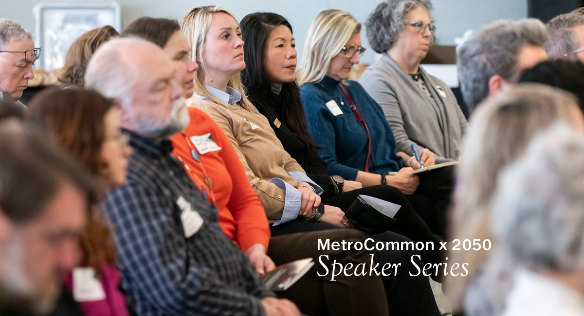Numerous people sitting in chairs looking towards the front of the room. Text on the image says, "MetroCommon x 2050 Speaker Series".