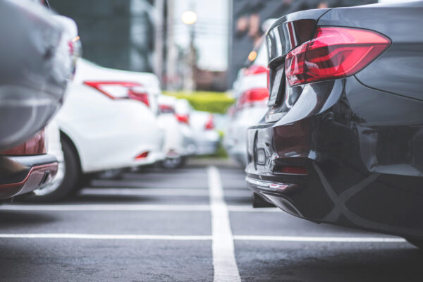 Black, gray, and white cars are parked in a parking lot.