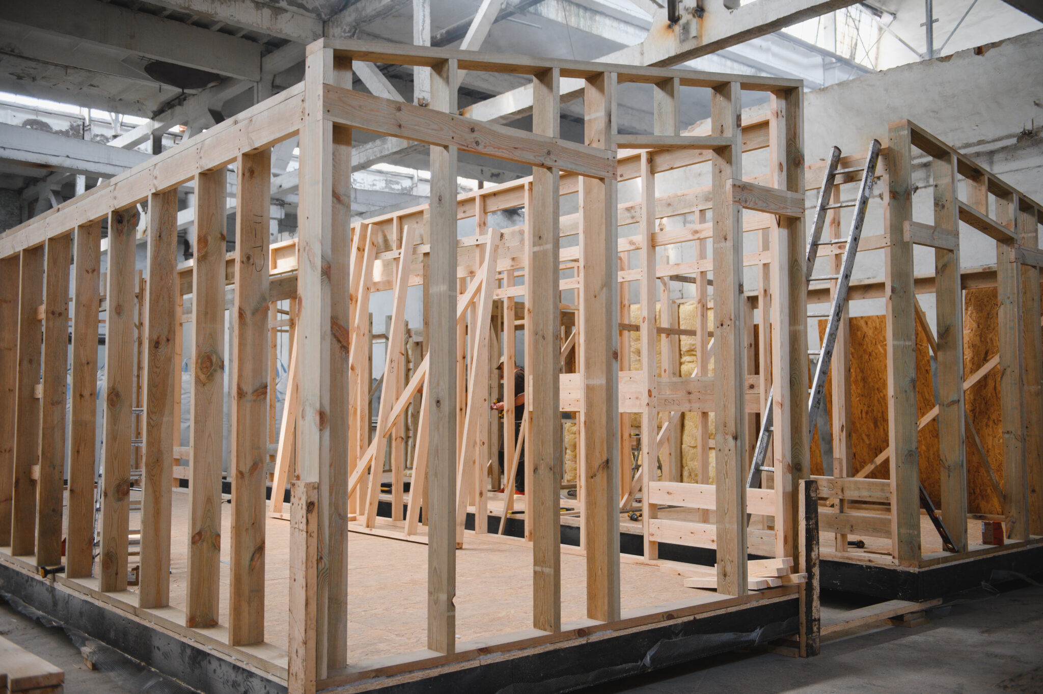 Production of new wooden modular houses. Construction site Construction of wooden modular homes being build inside of a large warehouse.