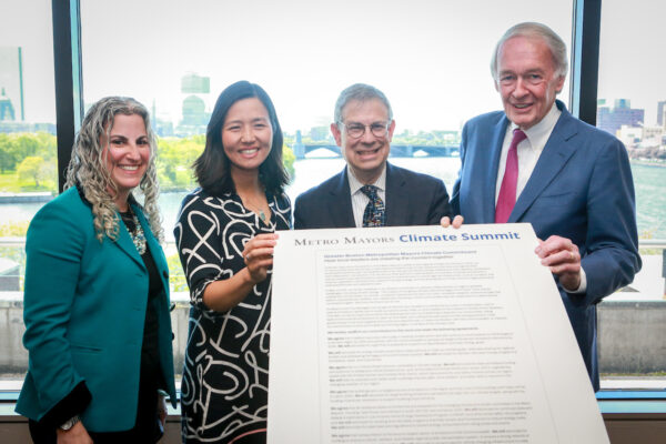 Standing left to right together, and holding the signed Climate Commitment: MAPC Deputy Executive Director Lizzi Weyant, Boston Mayor Michelle Wu, MAPC Executive Director Marc Draisen, and U.S. Senator Edward Markey.