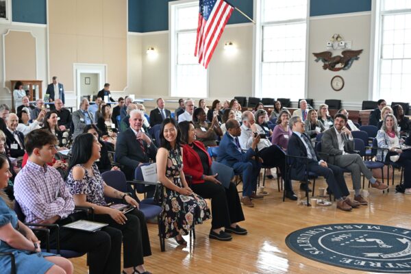 A room full of people sitting in chairs in the audience facing the front of the room at the 2025 Annual Council Meeting.