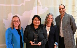 Pictured from left to right in front of a light green MAPC banner: Erin Wortman, Crystal Rosa, Lizzi Weyant, and Javier Gutierrez