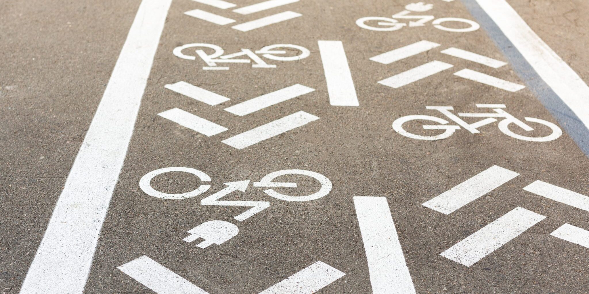 Asphalt road with bicycle and electric transport lane. Cycle and zero emission vehicles white sign on floor. Recreation area for green energy transport in city park Asphalt road with bicycle and electric transport lane. Cycle and zero emission vehicles white sign on floor. Recreation area for green energy transport in city park.