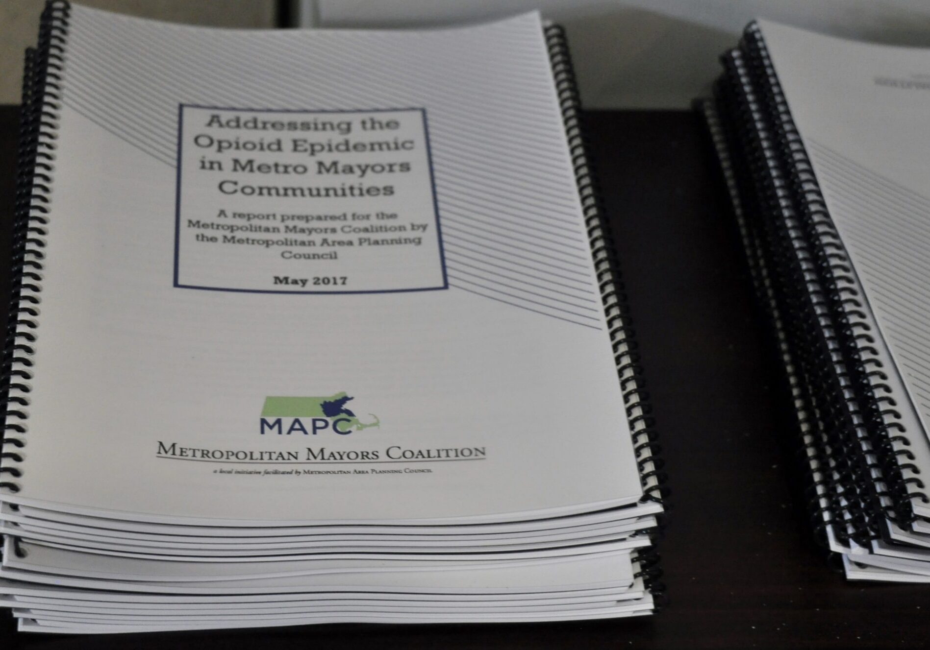 Opioid report Photo is of a stack of spiral publications.